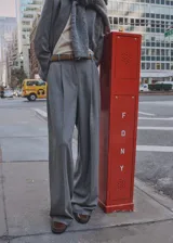 Pantalón de vestir gris con corte wide leg, tiro alto, pinzas y trabillas para cinturón.