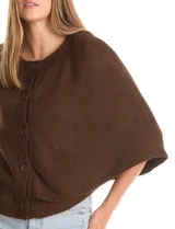 Capa de punto color bordó con diseño envolvente de doble capa superpuesta. Presenta cuello a la base, cierre frontal con botones y mangas estilo japonés con terminaciones acanaladas.