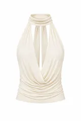Top de tela alicrada color marrón, con cuello halter y diseño de caída tipo buche en el frente. Presenta espalda descubierta.