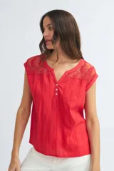 Blusa roja de algodón con cuello en V y detalle de encaje floral en el canesú.