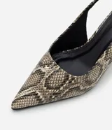 Zapato tipo slingback con estampado de piel de serpiente, puntera fina y taco anabela de 5 cm. Cuenta con tira ajustable en el talón con hebilla metálica.