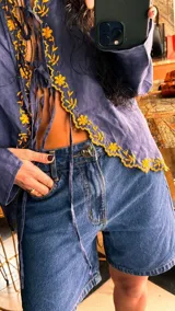 Bermuda de jean color negro, con corte recto y largo hasta la rodilla.