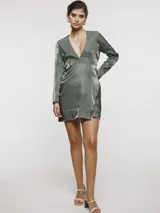 Vestido corto de satén color verde oliva, con escote en V profundo, mangas largas y diseño cruzado con falda estilo pareo.