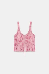 Top de tul semitransparente color rosado con estampado y bordado de lentejuelas a tono. Presenta escote redondo, tirantes anchos y cierre frontal con finas lazadas.