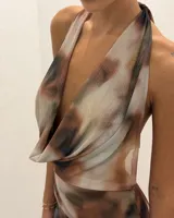 Vestido midi de malla con estampado abstracto en tonos tierra, cuello halter con escote drapeado y diseño sin mangas.
