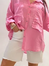 Camisa negra de manga larga con cuello clásico y cierre frontal con botones.