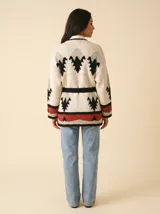 Cardigan de punto en color crudo con diseño de motivos navajo en tonos rojo, negro y verde claro. Presenta un corte holgado, mangas largas y terminaciones en tejido acanalado.