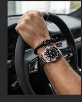 Pulsera de diseño trenzado en color negro, confeccionada en cuerina con un nudo metálico central y cierre magnético.