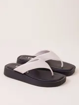 Sandalias de dedo color crudo con plataforma baja color negro.