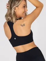 Top deportivo negro de soporte medio, con diseño de espalda estilo nadador y sujetador integrado. Incluye almohadillas removibles.