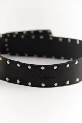 Cinto faja de cuero con estampado de vaca en blanco y negro, con hebilla metálica rectangular.