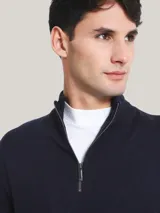 Sweater azul marino de lana merino con cuello alto y cremallera metálica plateada.