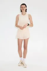 Musculosa deportiva de color beige, confeccionada en tejido funcional con tecnología DryMove para absorber el sudor. Presenta un diseño de corte estándar, cuello redondo y aberturas laterales en el bajo.