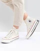 Championes Converse Chuck 70 Hi color beige con detalles en rojo y azul en la suela.