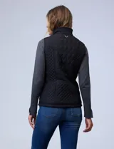 Chaleco negro capitoneado con abertura central con cierre, bolsillos delanteros con botones y forro de abrigo.