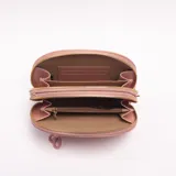 Bandolera de cuero sintético color rosado, con diseño semicircular, cierre frontal con tirador de cordón y herrajes metálicos dorados. Incluye correa ajustable extraíble.