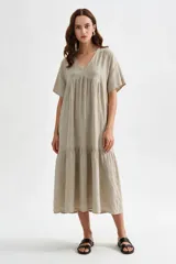 Vestido midi marrón de corte holgado, con escote en V, mangas cortas y detalle de volados fruncidos en el pecho y en el ruedo.