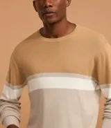 Suéter de punto color beige con bloques de color marrón, blanco y beige claro. Tiene cuello redondo y mangas largas.