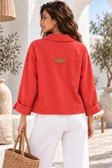Chaqueta de gabardina blanca con botones marrones contrastantes, bolsillos frontales grandes y mangas largas con vuelta.