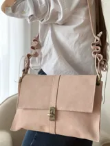 Bandolera de cuero color beige claro, con solapa frontal, cierre metálico de broche y correa regulable con detalles ondulados.