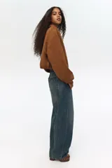 Jean de cinco bolsillos en denim de algodón, de cintura estándar, diseño curvo y corte holgado con efecto desgastado.