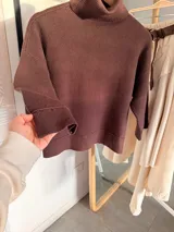 Sweter de punto con cuello alto tipo polera, de calce holgado y mangas tres cuartos con puños acanalados.