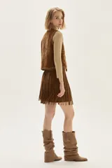 Chaleco de cuero color camel con bordados decorativos, tachas metálicas en los bordes y cierre frontal mediante lazos.