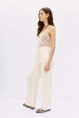 Pantalon palazzo de tiro alto, confeccionado en tejido de cupro y viscosa con textura sedosa. Presenta un diseño de corte recto con caída fluida, largo al piso y bolsillos laterales.