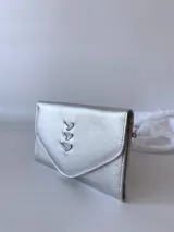 Billetera plateada de cuero con cierre de broche y monedero externo.