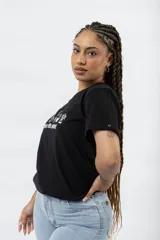 Remera blanca de algodón con estampa frontal en color negro que incluye iconos de café y la frase 'More coffee, please!'. Presenta cuello redondo y mangas cortas.