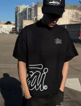 Remera negra oversize de manga corta con cuello redondo y estampa gráfica en color celeste en el pecho y el lateral inferior.