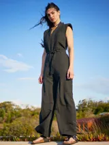 Mono color arena de lino, con cuello mao, cierre frontal con cremallera, mangas cortas y cinturón de lazo.