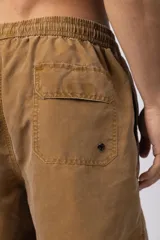 Short de baño color marrón claro con efecto acid wash, cintura elastizada con cordón ajustable y bolsillos laterales. Presenta un pequeño parche con logo en la parte inferior delantera.