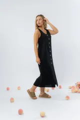 Vestido largo de lino con escote en V, diseño recto y fluido, con cierre frontal abotonado mediante botones de madera.