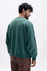 Buzo deportivo verde con cuello redondo, manga larga y corte holgado. Presenta líneas blancas decorativas en las mangas y hombros, y la palabra "BONELESS" estampada en el pecho.