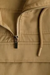Campera popover color tostado confeccionada en sarga de mezcla de algodón y lyocell. Cuenta con capucha con cordón ajustable, medio cierre frontal y un amplio bolsillo delantero con solapa. Presenta diseño de hombros caídos, canesú frontal, mangas abullonadas con pliegues, puños con cierre ajustable de botón y bajo con cordón interior para fruncir.