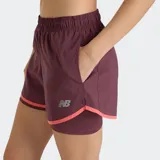 Short deportivo New Balance 2 en 1 para mujer, color bordó con ribetes en color coral. Confeccionado con tecnología NB DRY de secado rápido, incluye una calza interna para mayor soporte, bolsillos laterales y cintura elástica.