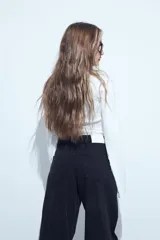 Jean de corte recto y calce relajado color negro, confeccionado en denim estructurado, con detalles de tachas metálicas plateadas en los laterales.