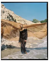 Vestido corto negro de tul con mangas largas abullonadas y detalles de flores aplicadas. Incluye viso negro.