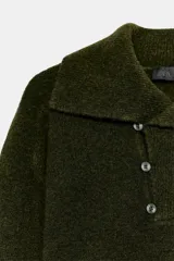 Jersey de punto color verde oliva, con cuello solapa y cierre frontal cruzado con botones. De manga larga y corte recto.