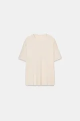 Camiseta de manga corta y cuello redondo, calce regular, color crema con textura jaspeada.