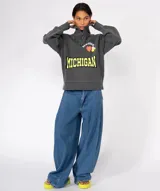 Buzo de algodón gris oscuro con lavado suave, cuello tipo trucker con cierre frontal y mangas largas. Presenta apliques decorativos: la palabra "NEWTONE" en blanco sobre un corazón naranja, un limón y la palabra "MICHIGAN" en amarillo con borde negro.