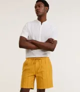 Bermuda recta de playa en color blanco roto, confeccionada en algodón texturizado con efecto de rayas verticales. Posee cintura elástica con cordón ajustable.