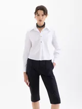 Camisa blanca de manga larga con cuello clásico y botones de diferentes colores.