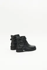Bota de caña media confeccionada en cuero vacuno negro, con diseño de estilo rockero. Presenta dos tiras decorativas con remaches y hebillas metálicas a tono, laterales con detalle matelaseado y cierre lateral interno.