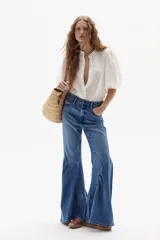 Jeans acampanados de tiro alto, color azul índigo lavado, con vuelo en el ruedo y confeccionados en denim de algodón con spandex.