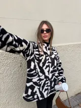 Buzo de peluche con estampado animal print de leopardo, de corte oversize, cuello redondo y mangas largas.