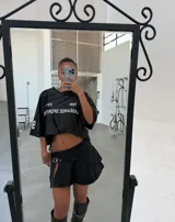 Minifalda de tiro bajo confeccionada en denim negro, con diseño plisado y detalle de hebilla frontal. Presenta un tajo lateral que aporta un estilo moderno y audaz.