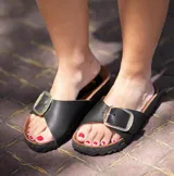 Sandalias negras de cuero con hebilla plateada.