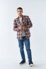 Sobrecamisa de algodón a cuadros color ladrillo, con interior de corderito, cierre con botones, bolsillos tipo cartera y logo en goma. El modelo usa talle M.